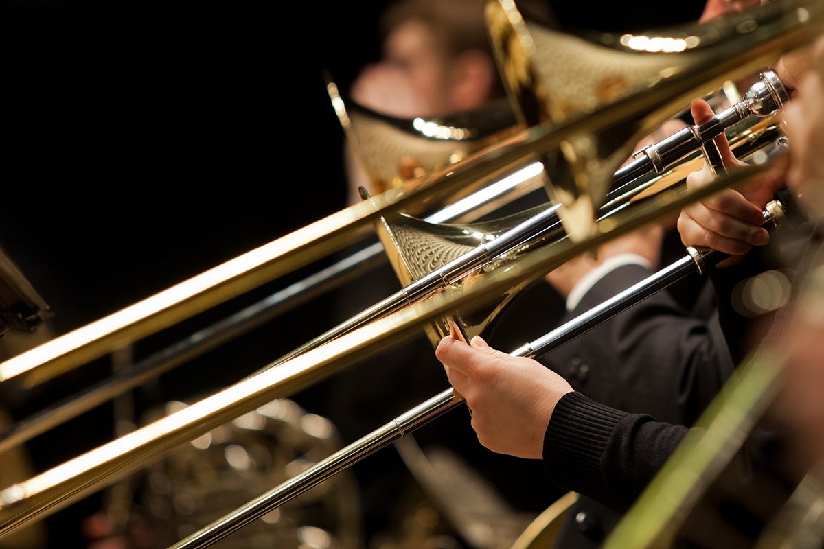 Hands of man playing the trombone in the orchestra