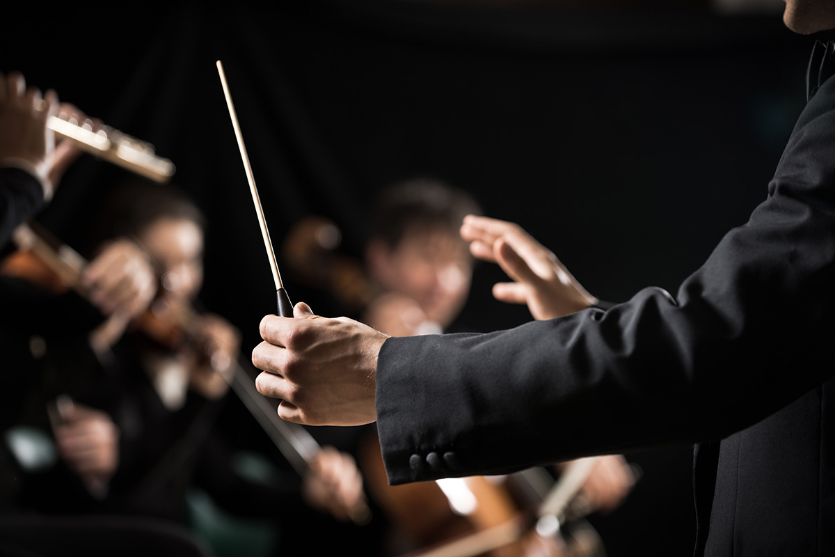 hands and baton of conductor with string in soft focus