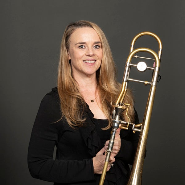 A portrait of Amy Bowers and her trombone