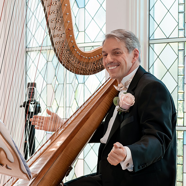 A portrait of Dan Levitan and his harp