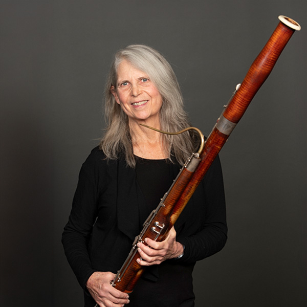 A portrait of Karla Ekholm and her bassoon