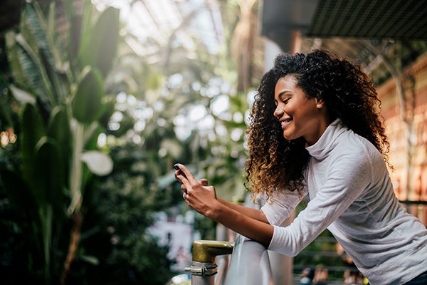 Side view of beautiful woman using her phone indoors.