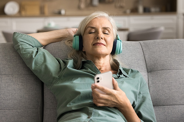 woman with eyes closed enjoying Spotify on headphones