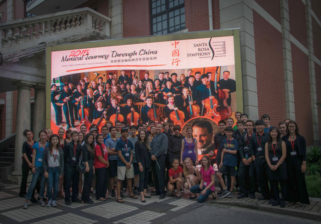 2015 Santa Rosa Youth Orchestra in front of a theater sign in China