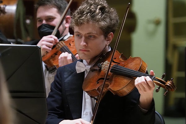 A close up of Dimitrios Floor performing with the orchestra