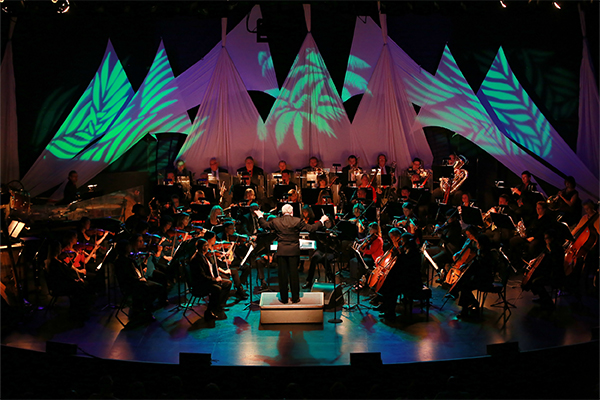Dramatic lighting and the orchestra performing on stage