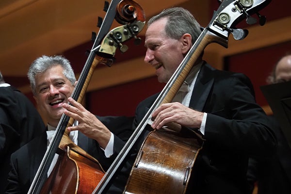 Ray and Andy performing with the orchestra and smiling