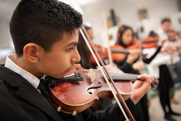 A close up of a young man playing violin