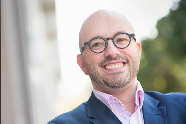 A portrait of Andrew Bradford smiling outside